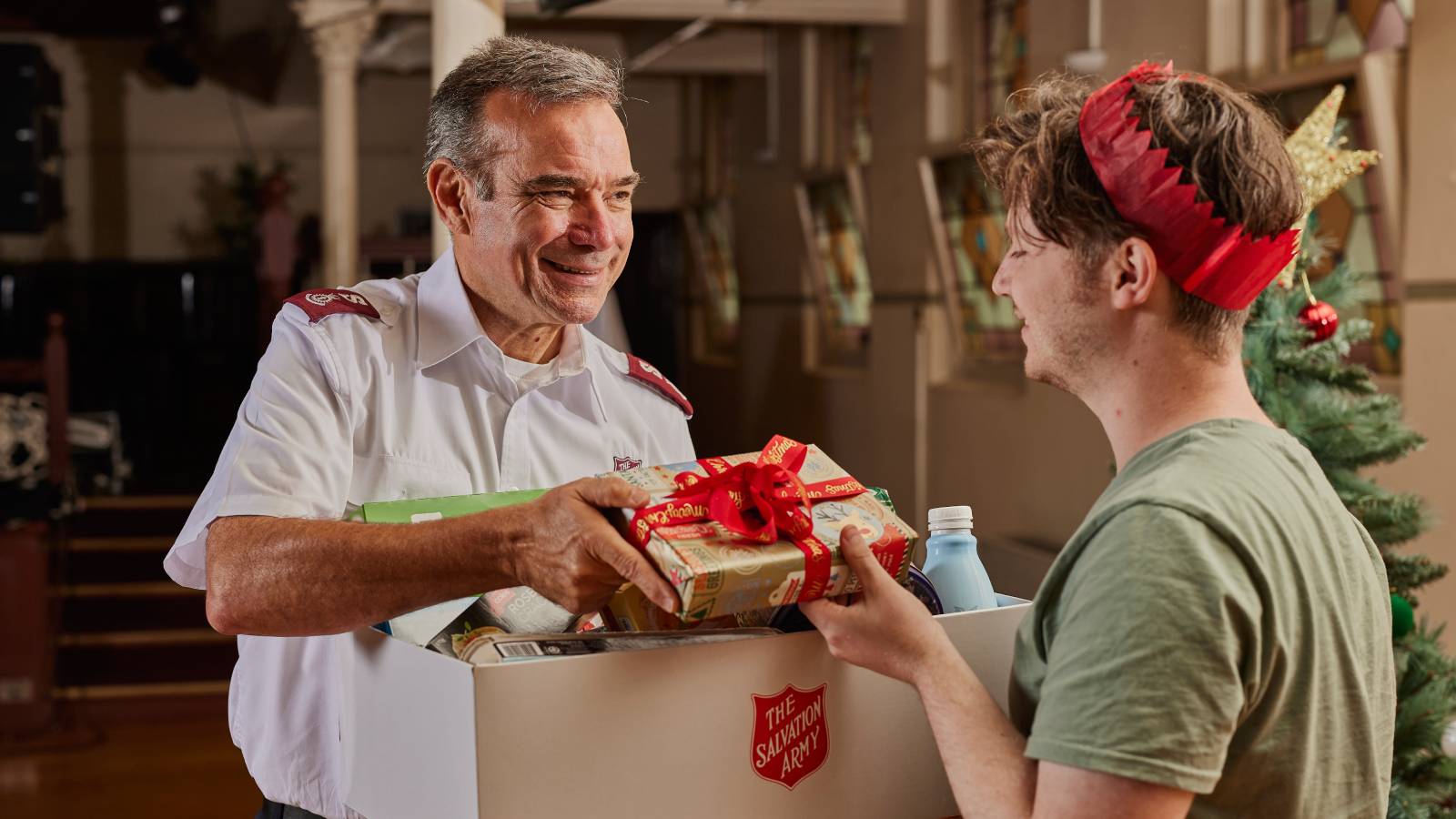Salvos officer handing over a Christmas gift