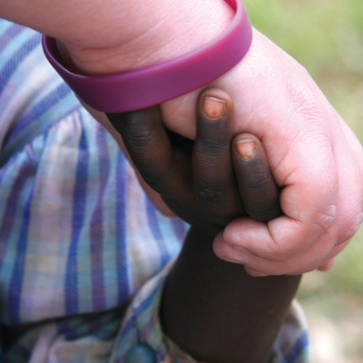 Close up: A young hand clasping an adult hand