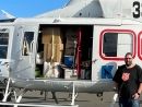 A Salvo standing next to a helecopter filled with supplied for flood victims